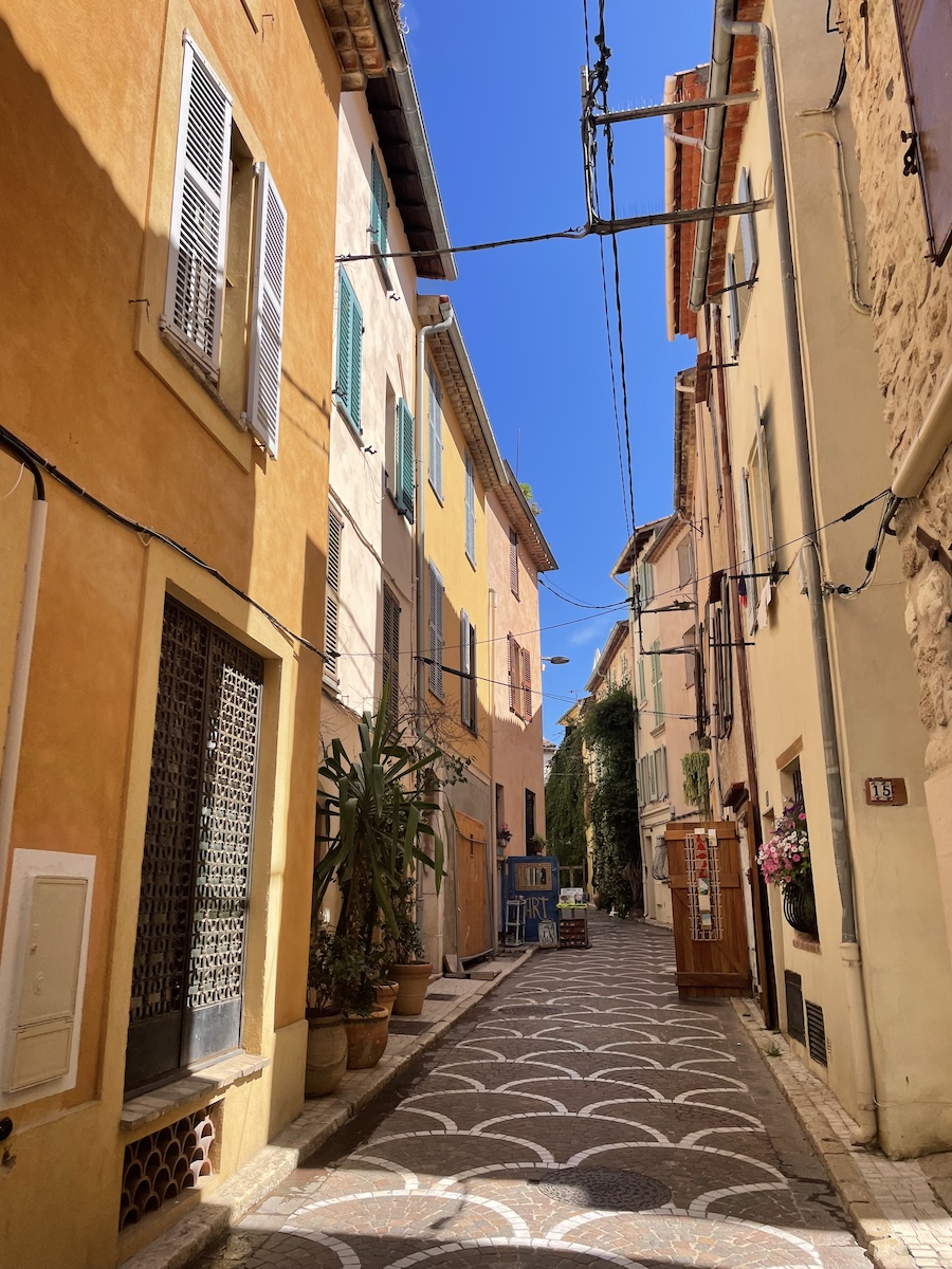 A narrow walkway with tall yellow concrete buildings