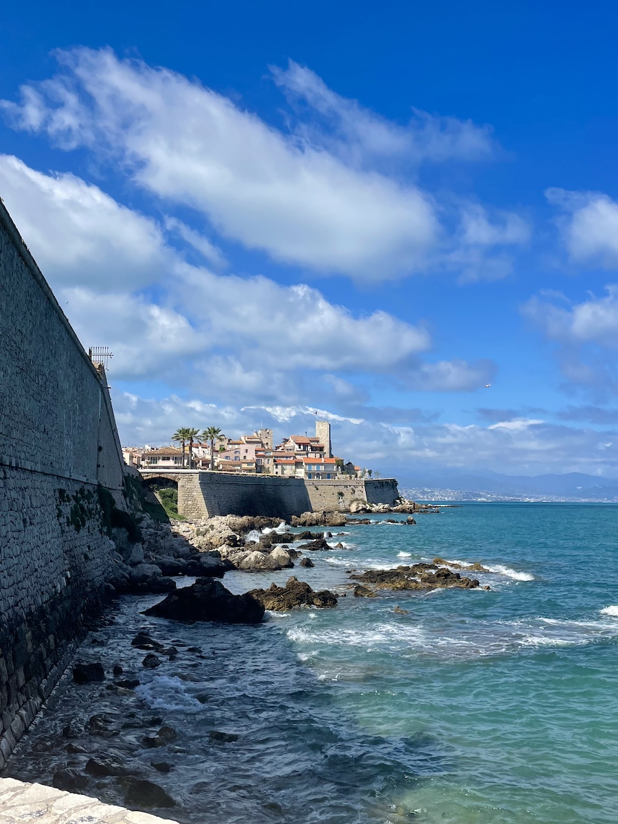 A side view of city with water and rocks below