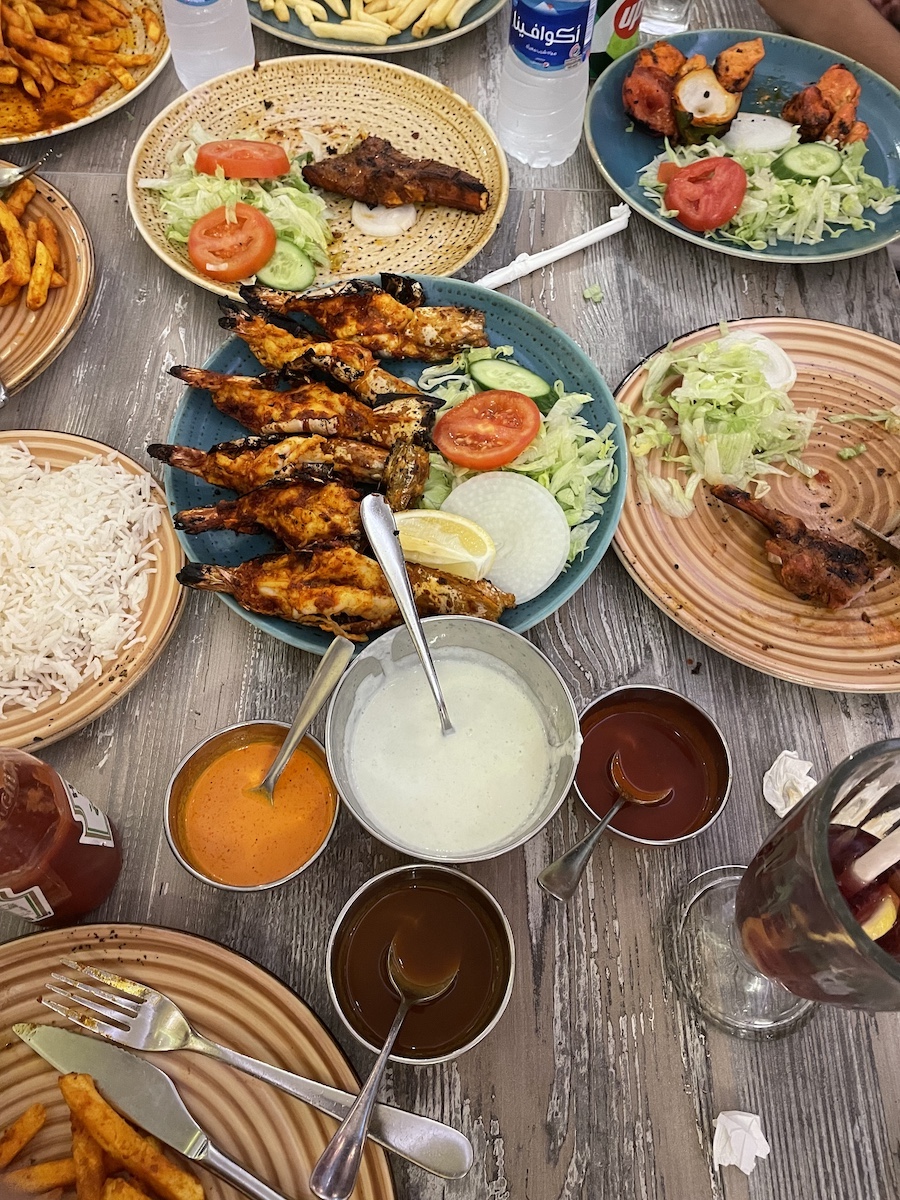 BBQ chicken, sauces, and vegetables in plates on a table