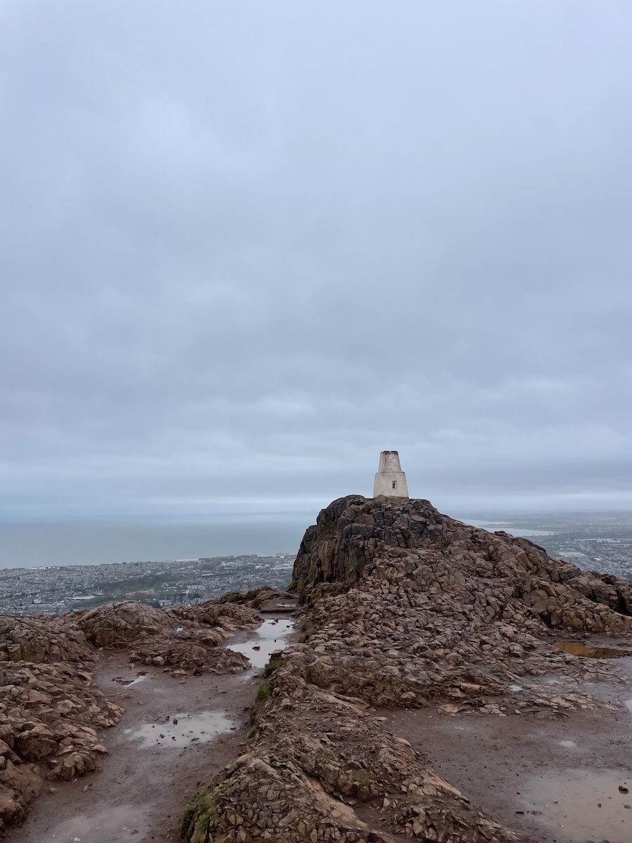 Small white stone of Arthur's Seat on top of mountain