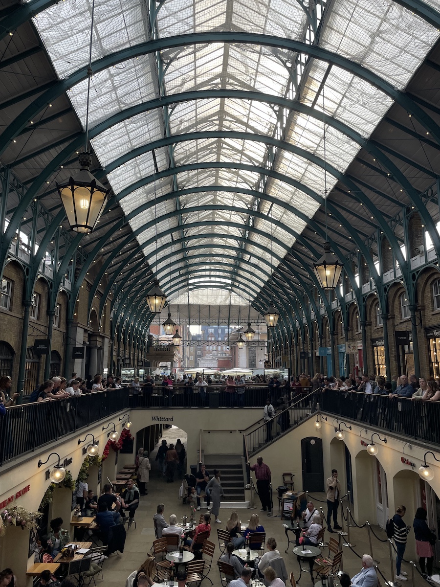 Curved ceilings with green beams over a seating area below