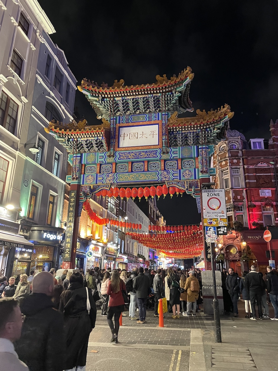 Big Chinatown arch with chinese lanterns hung and people walking