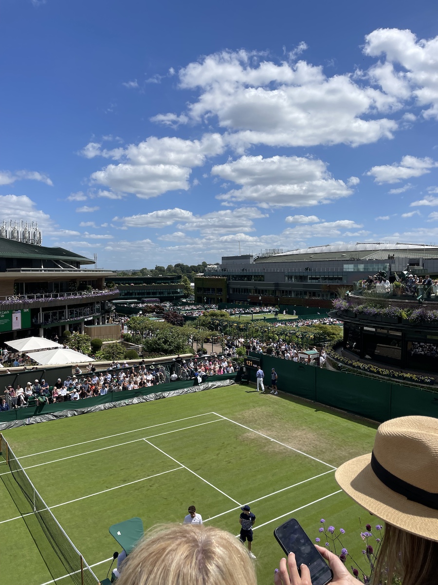 Grass tennis courts in high view, people watching or walking