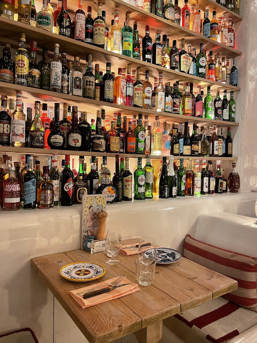 Rustic booth next to wall of colorful bottles