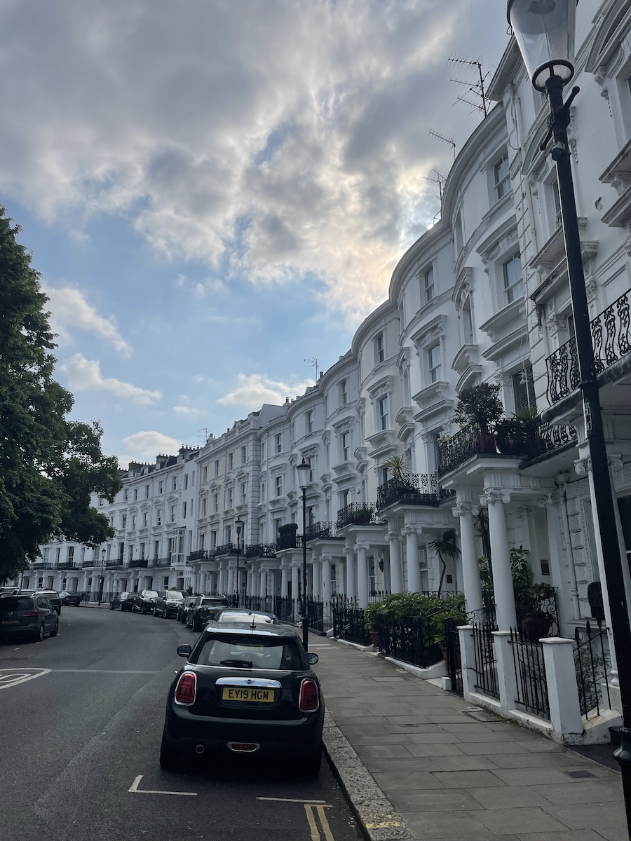 Car parked on curved street, with buildings curved on right side of street