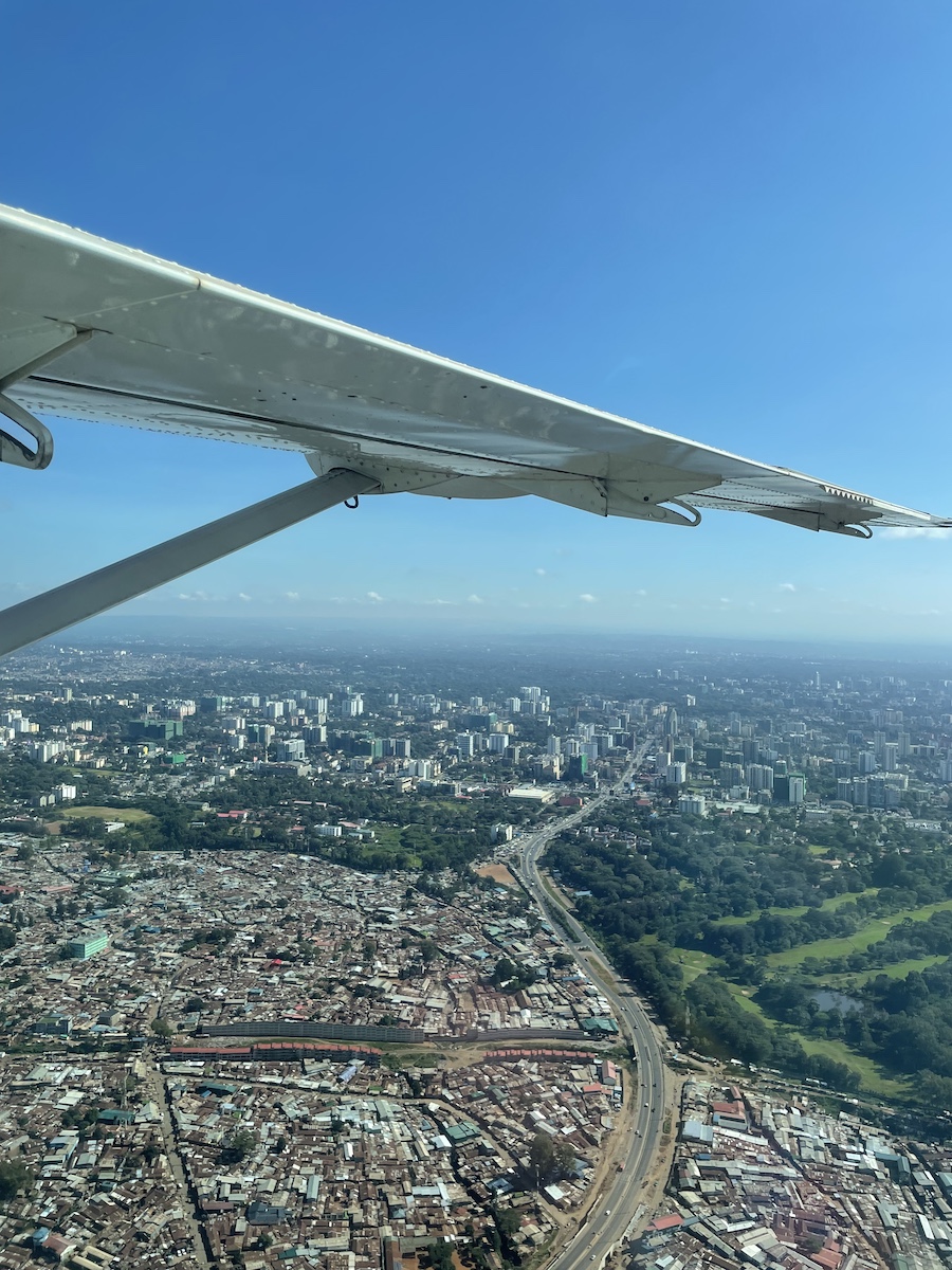 Nairobi city buildings below from a flying airplane wing