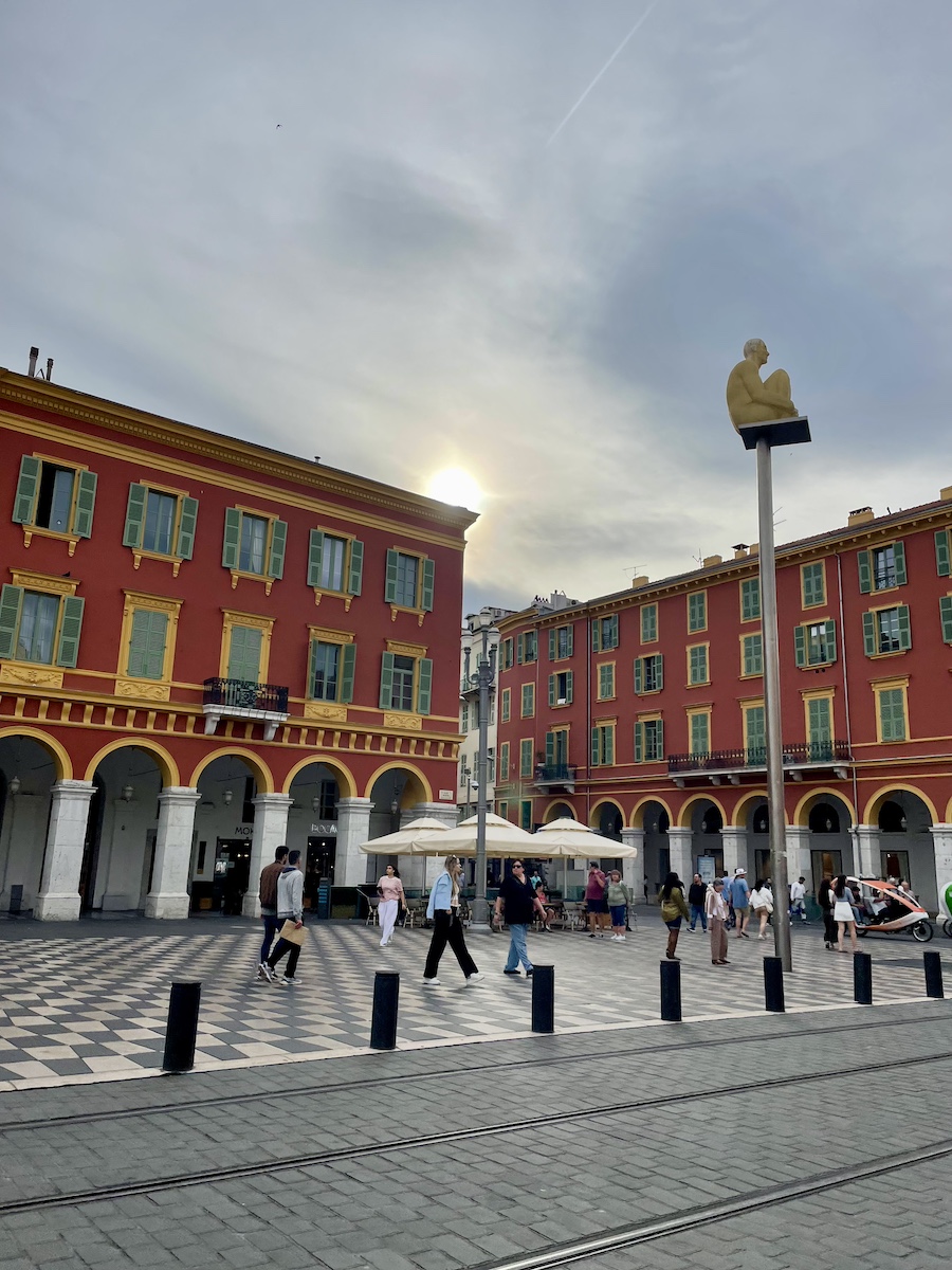 Checkered floor around red building with yellow window frames