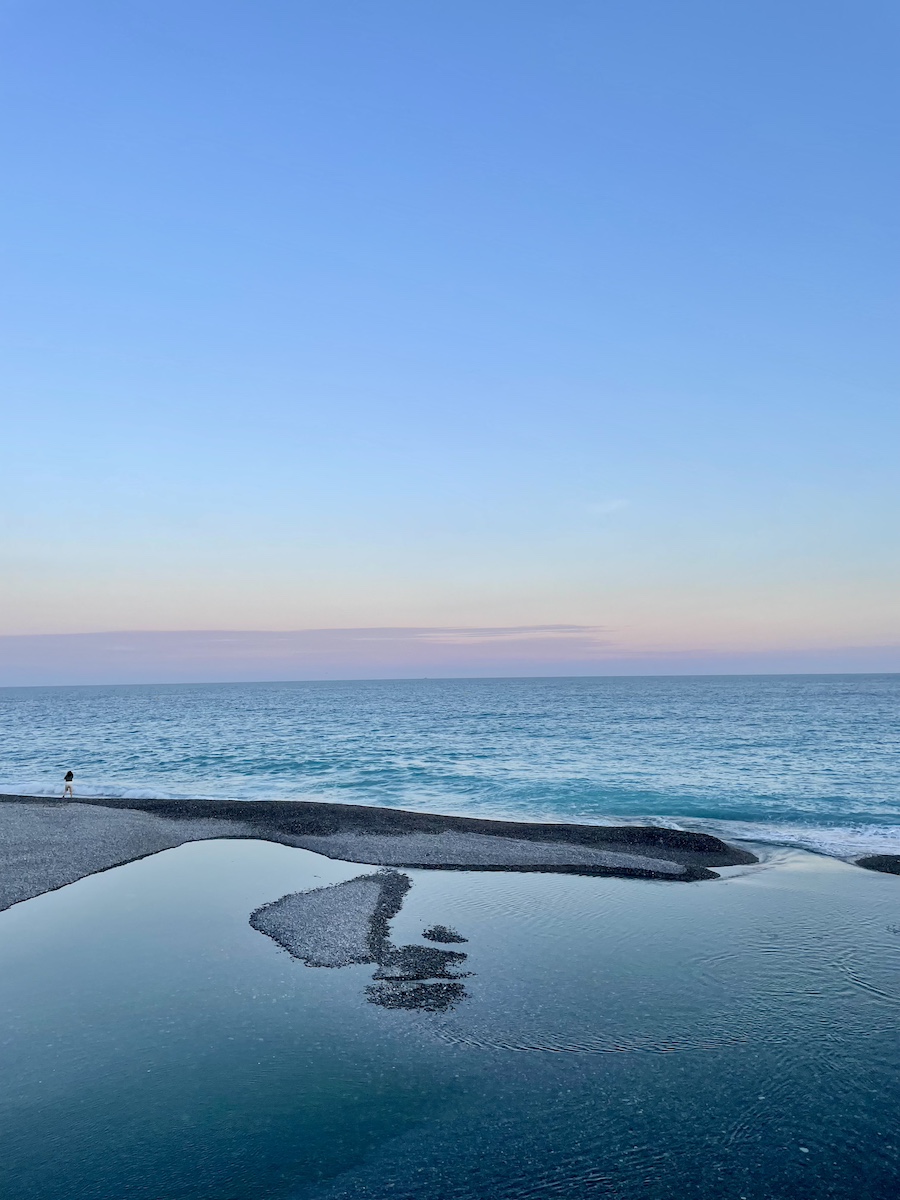 A reflection of sunset in small pond that connects to ocean
