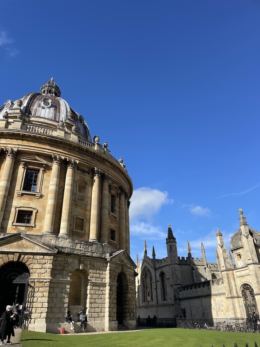Half of Radcliffe library on sunny day, with surrounding buildings