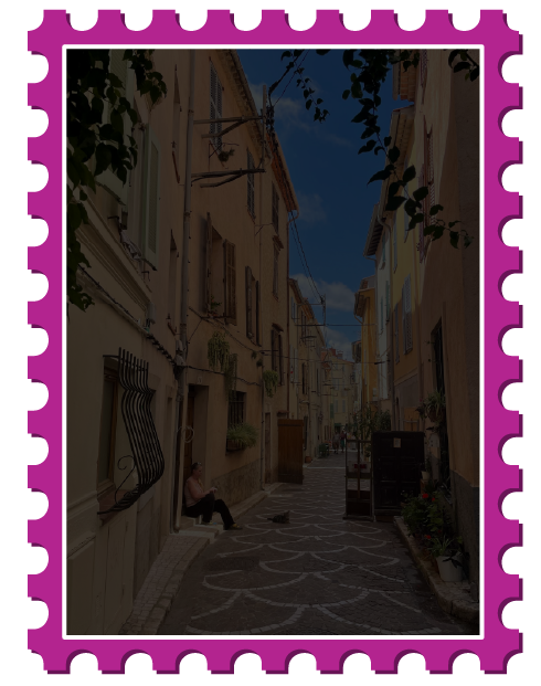 Walkway through tall yellow concrete buildings, tinted black to display text